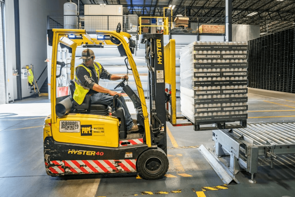 Forklift driver moving pallets around a warehouse