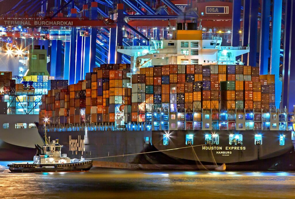 Full shipping container ship at night