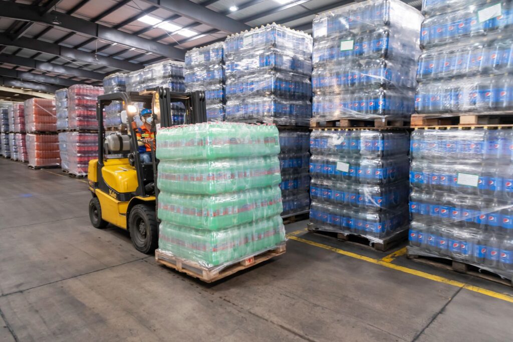 A forklift moves beverages in a warehouse