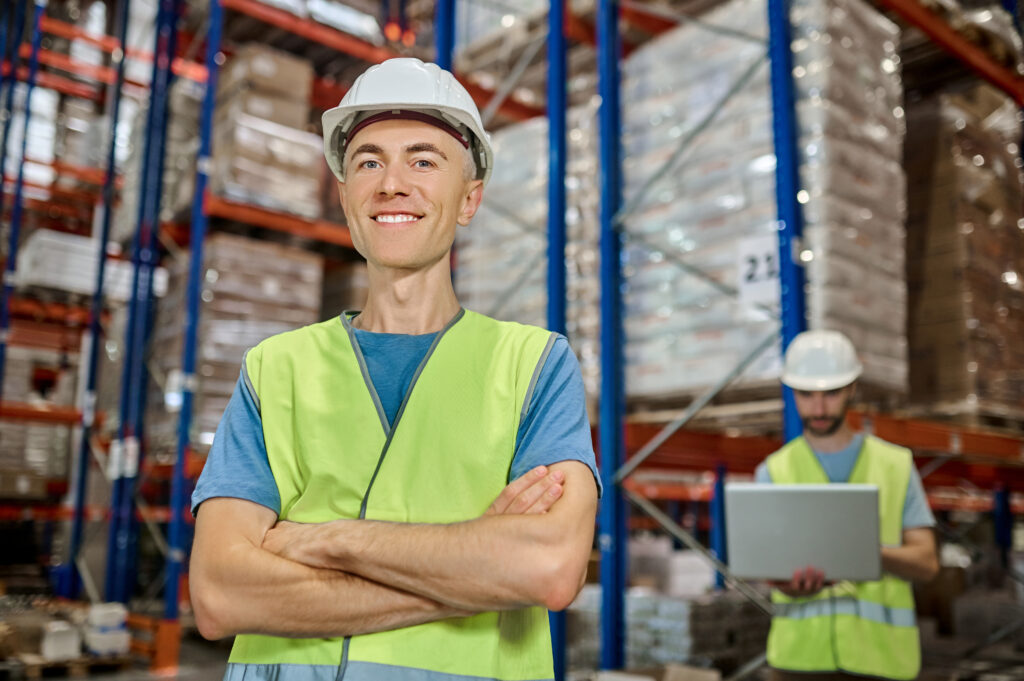 Four people are smiling while working in a warehouse